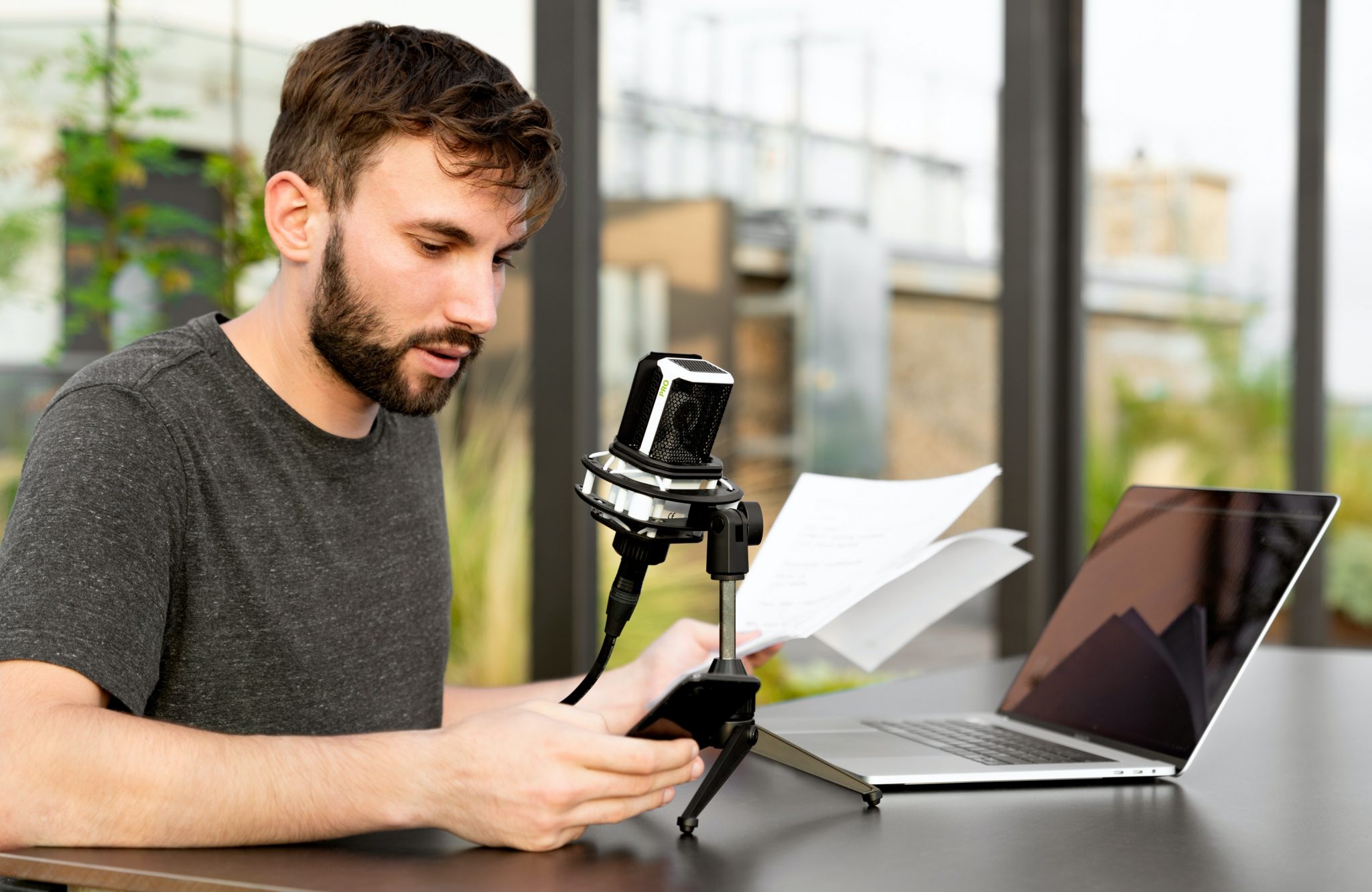 man in gray crew neck shirt using black and silver camera