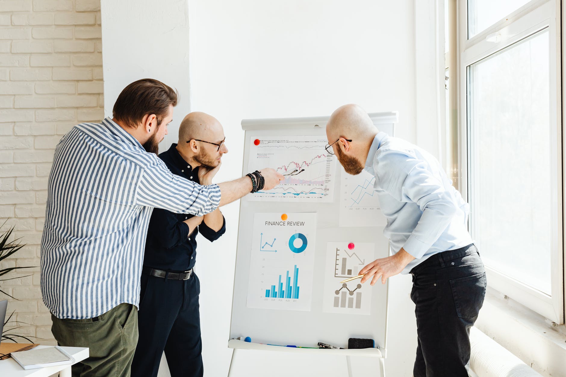 men looking at graphs on a whiteboard