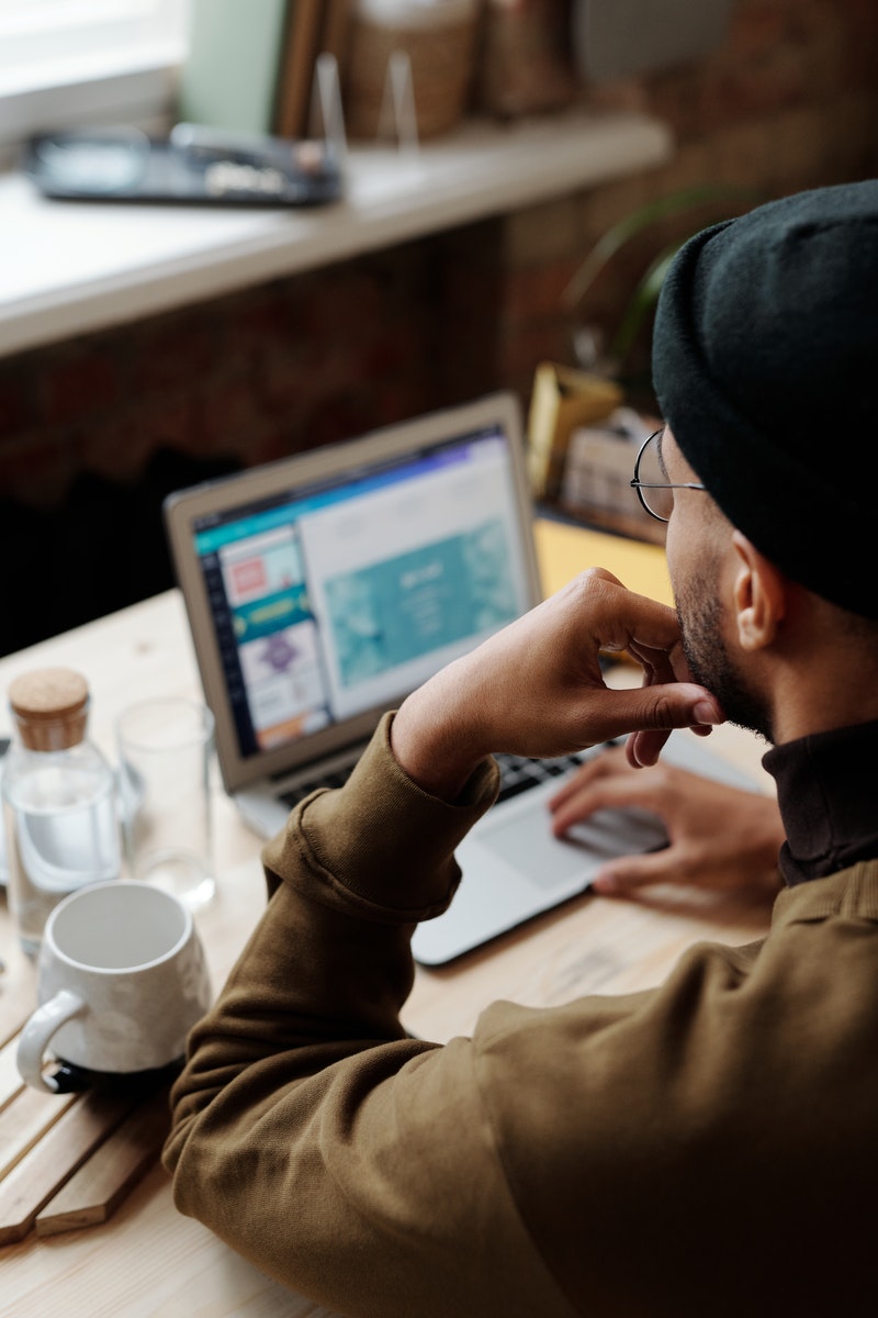 Man in Brown Long Sleeve Shirt Using Silver Macbook