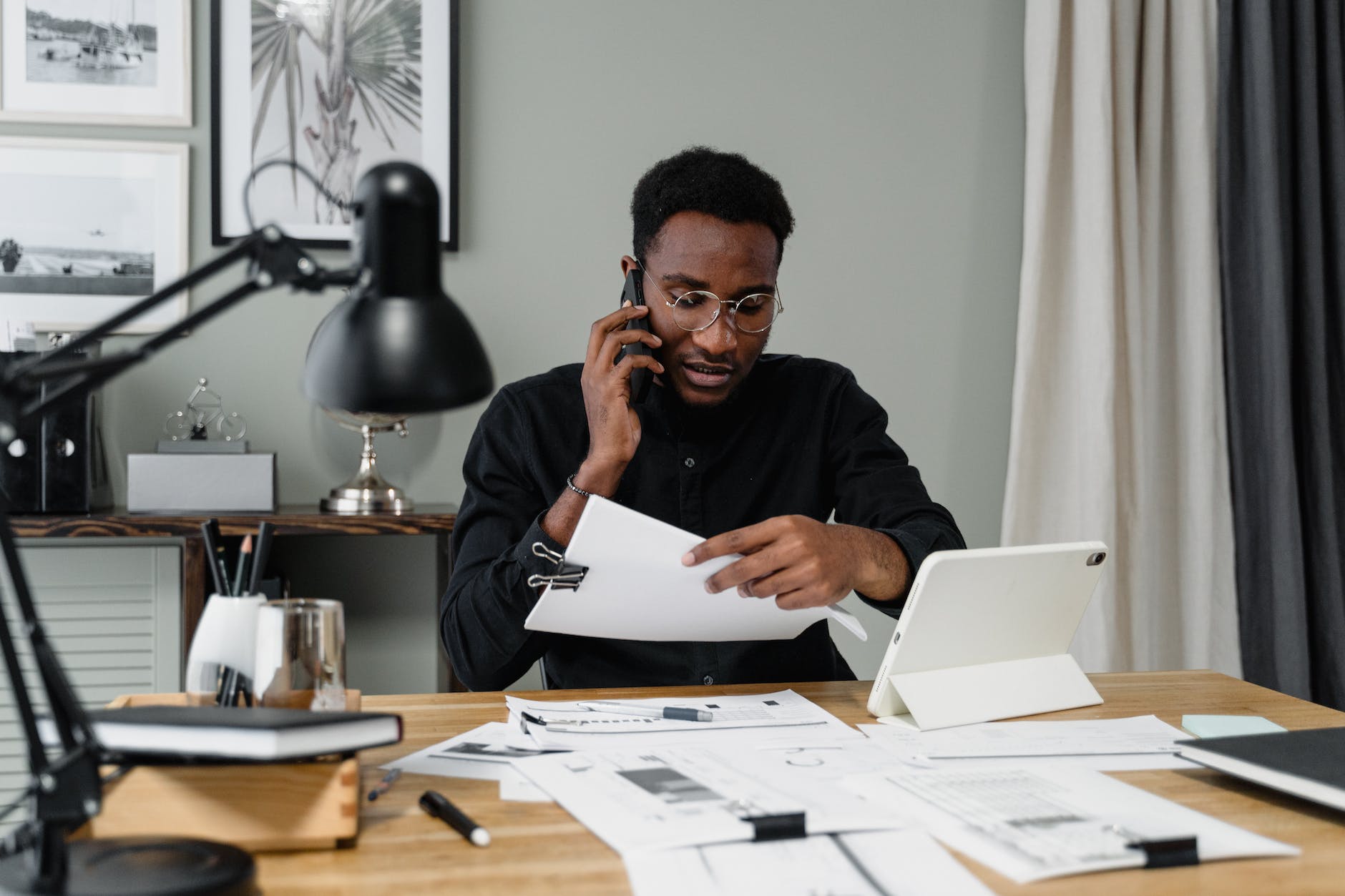 man in black long sleeves wearing eyeglasses while working in the office