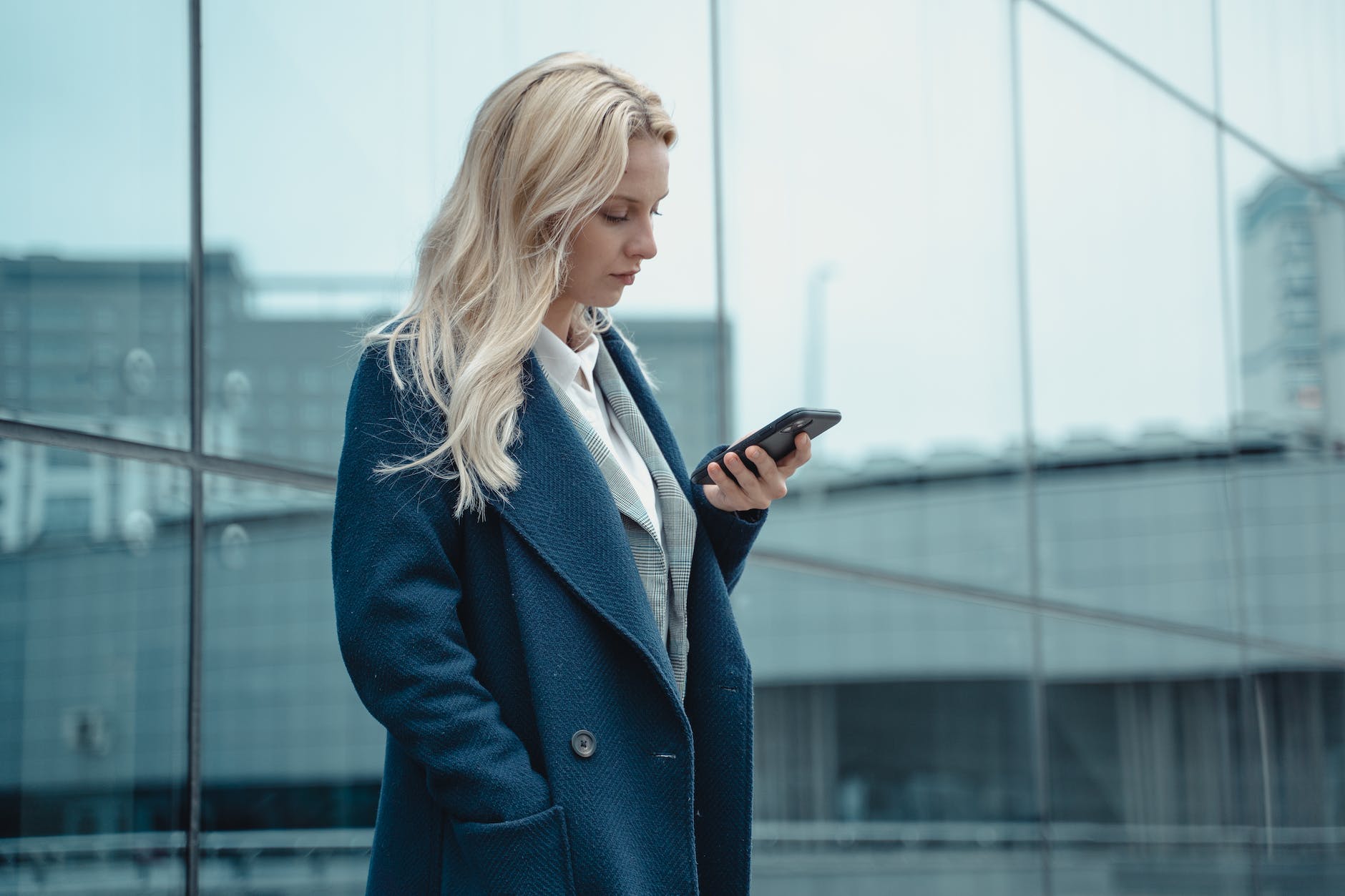 a woman in a blue coat using her phone