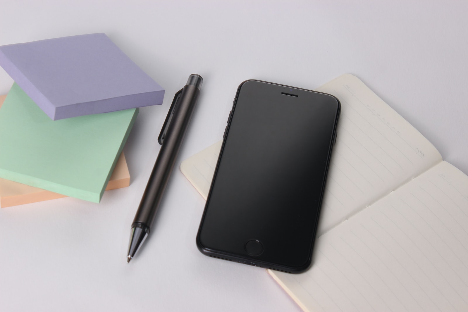 black iphone 4 beside black click pen