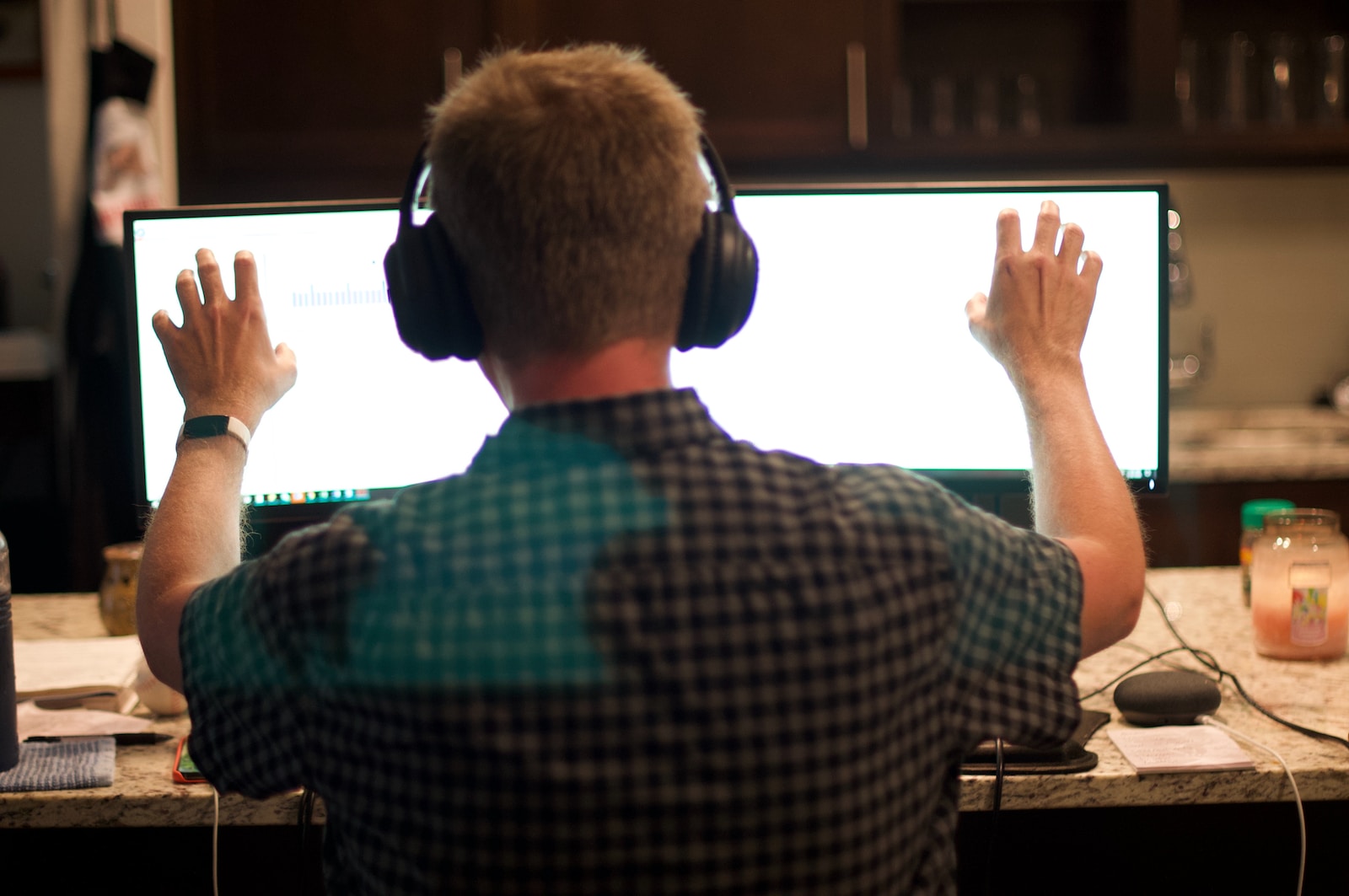 man in blue and white plaid shirt wearing black headphones