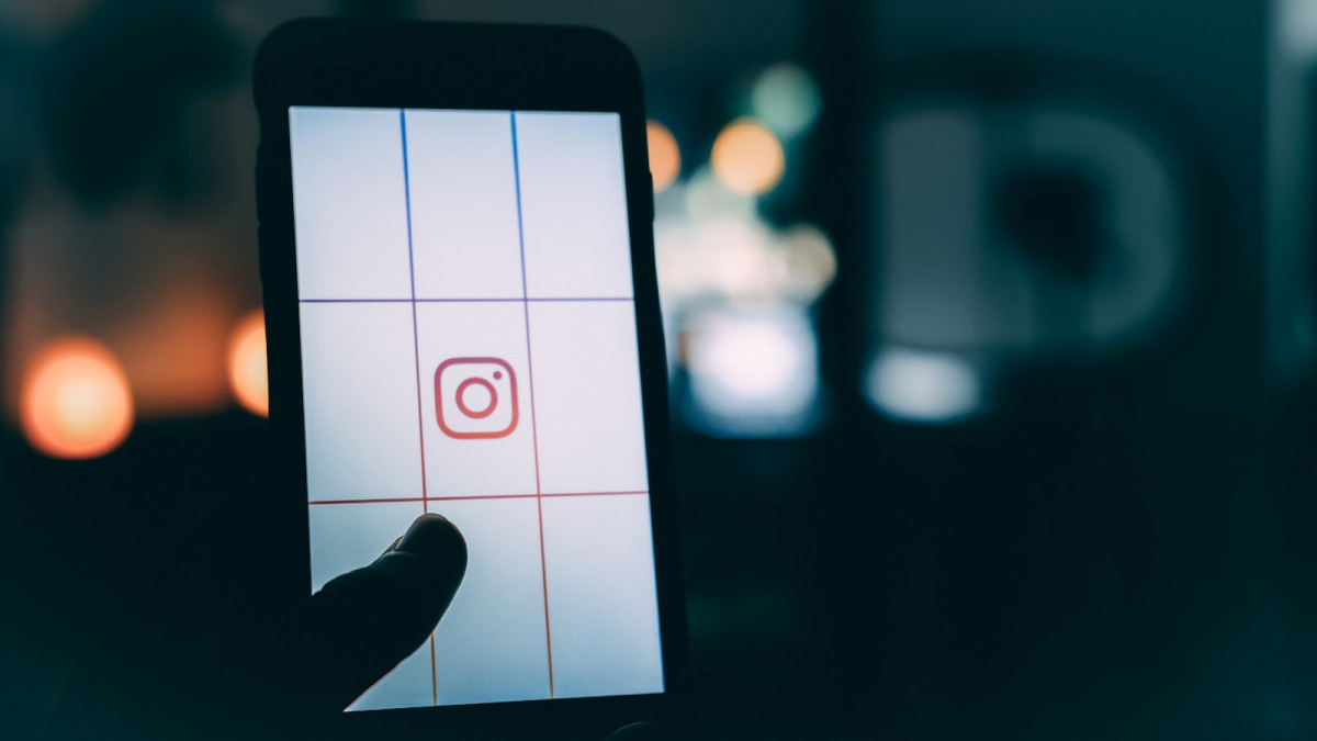 person using smartphone with Instagram logo screengrab bokeh photography