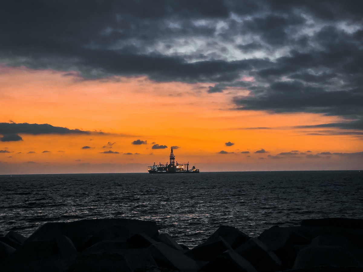 silhouette of people on sea during sunset