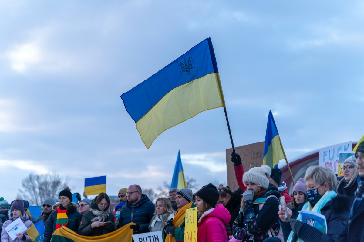 a crowd of people holding flags and signs