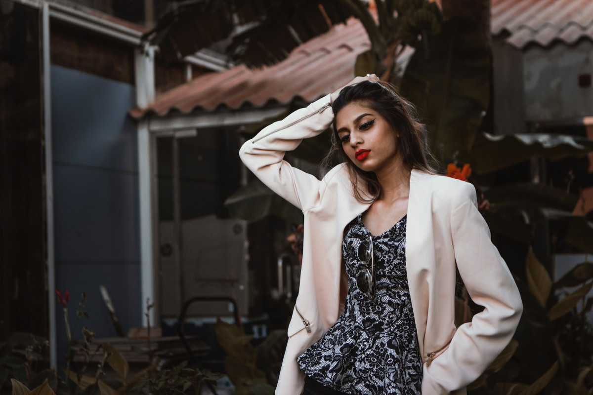 woman in white blazer standing and smiling