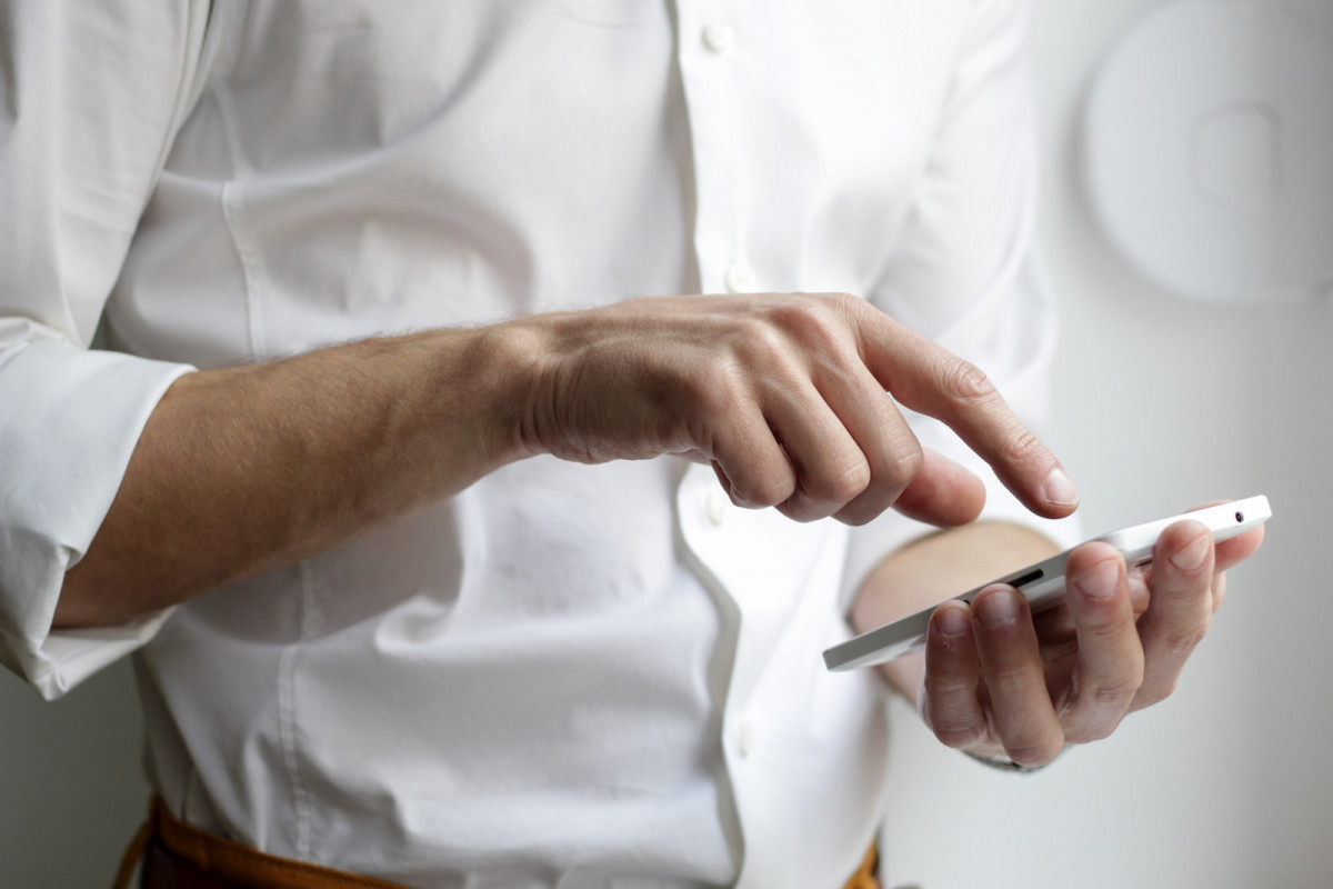 person holding white Android smartphone in white shirt. Phone Number Validation API
