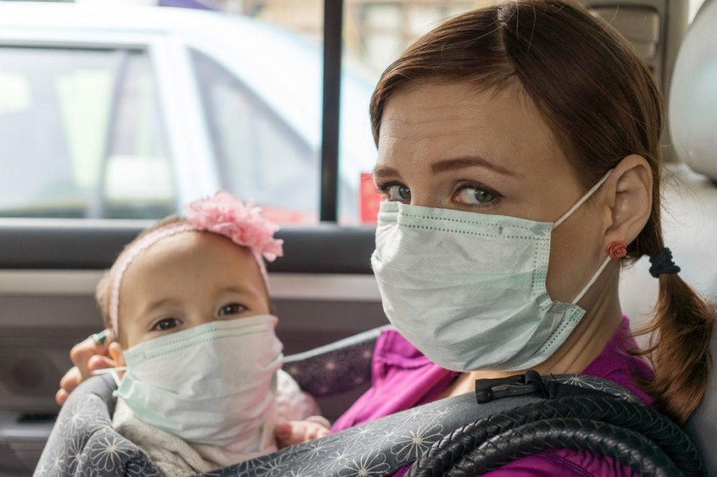 Woman and child waring a mask sitting inside vehicle - Masks Detection API in action